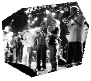 EIne Band, die auf einer Bühne Musik spielt